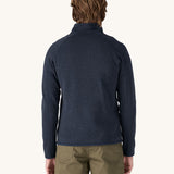 A man wearing the Patagonia Men's Better Sweater Jacket in a New Navy colour. He is facing away from the camera showing the back of the jacket.
