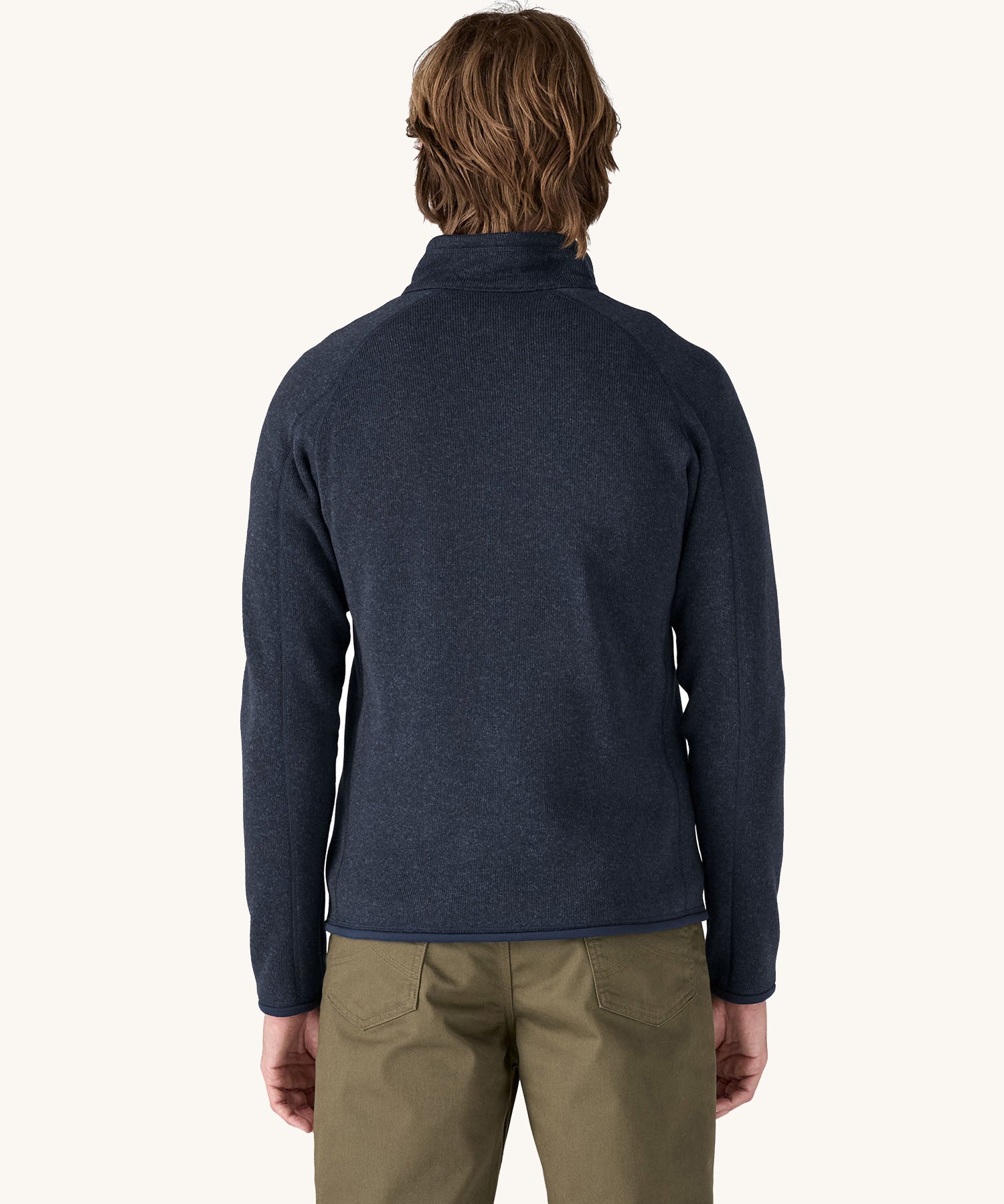 A man wearing the Patagonia Men's Better Sweater Jacket in a New Navy colour. He is facing away from the camera showing the back of the jacket.