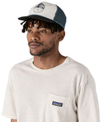 Patagonia airfarer cap in a birch white colour and Chouinard crest design worn by an adult 