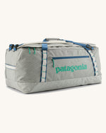 Patagonia black hole 70l duffel bag in birch white with blue zip details and mint green printed logo. 