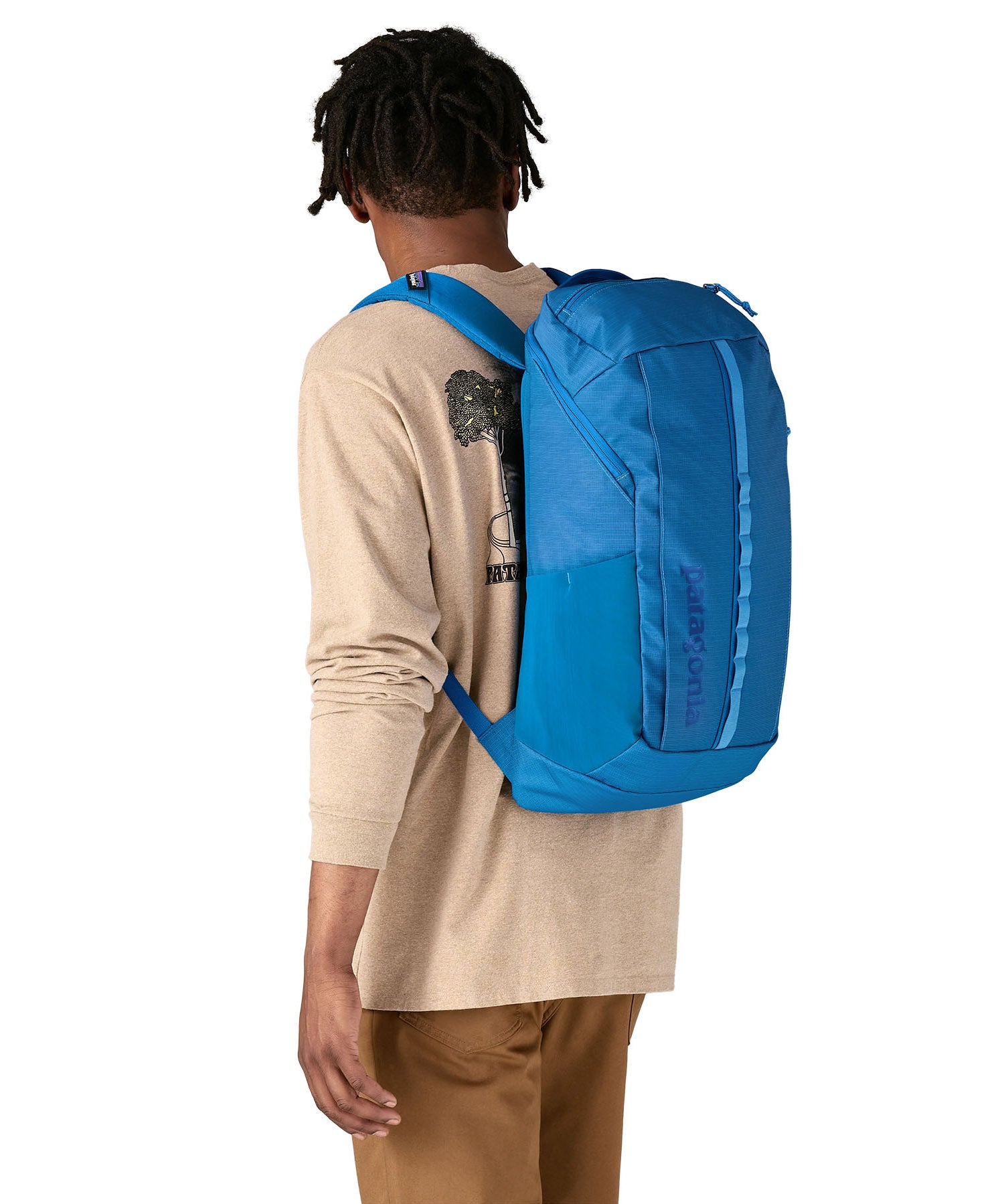 An adult wearing the The Patagonia Black Hole Backpack 25 litre capacity backpack, in endless blue.