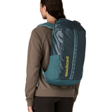 A woman wearing the Patagonia Black Hole Backpack 25L on her back, in a Tidal Teal blue colour palette. 