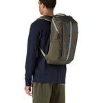 Patagonia 25L black hole backpack in a basin green colour worn by an adult