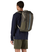 Patagonia 25L black hole backpack in a basin green colour worn by an adult