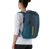 Patagonia 25L black hole backpack in a tidal teal colour worn by an adult 