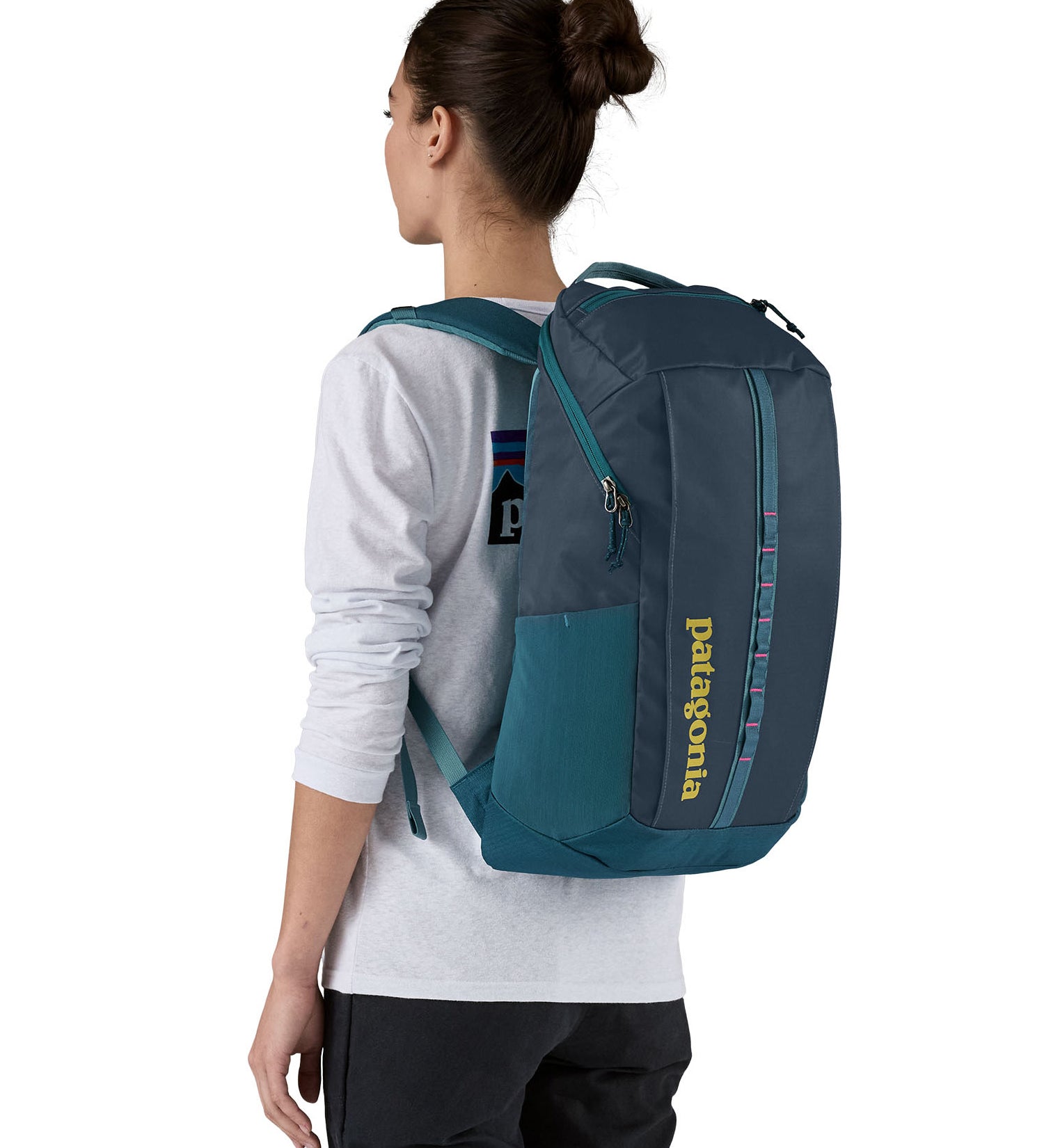 Patagonia 25L black hole backpack in a tidal teal colour worn by an adult 
