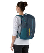 Patagonia 25L black hole backpack in a tidal teal colour worn by an adult 