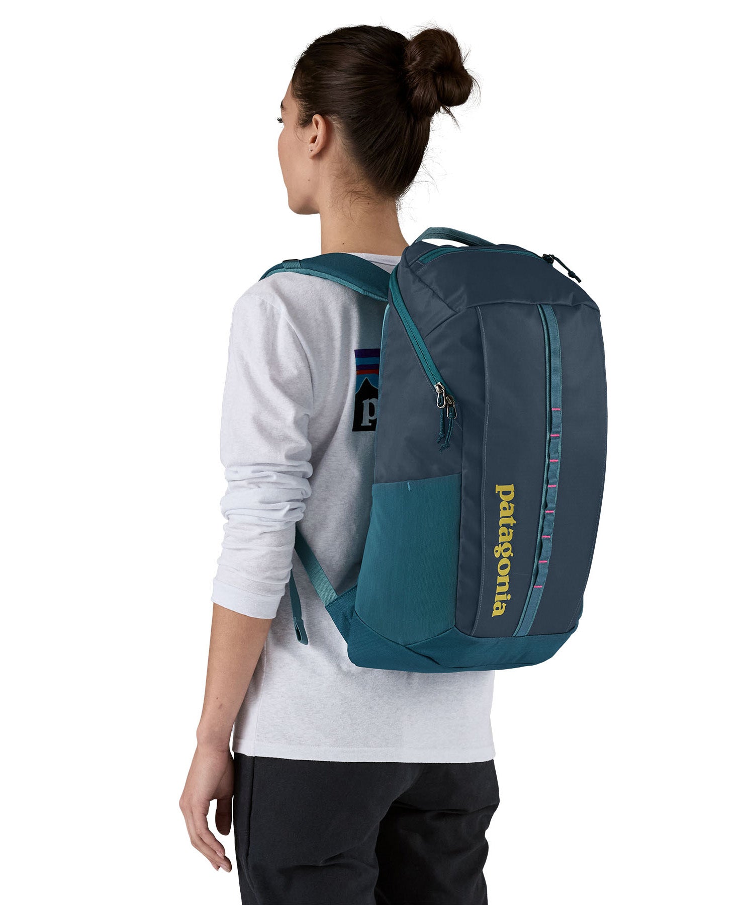 Patagonia 25L black hole backpack in a tidal teal colour worn by an adult 