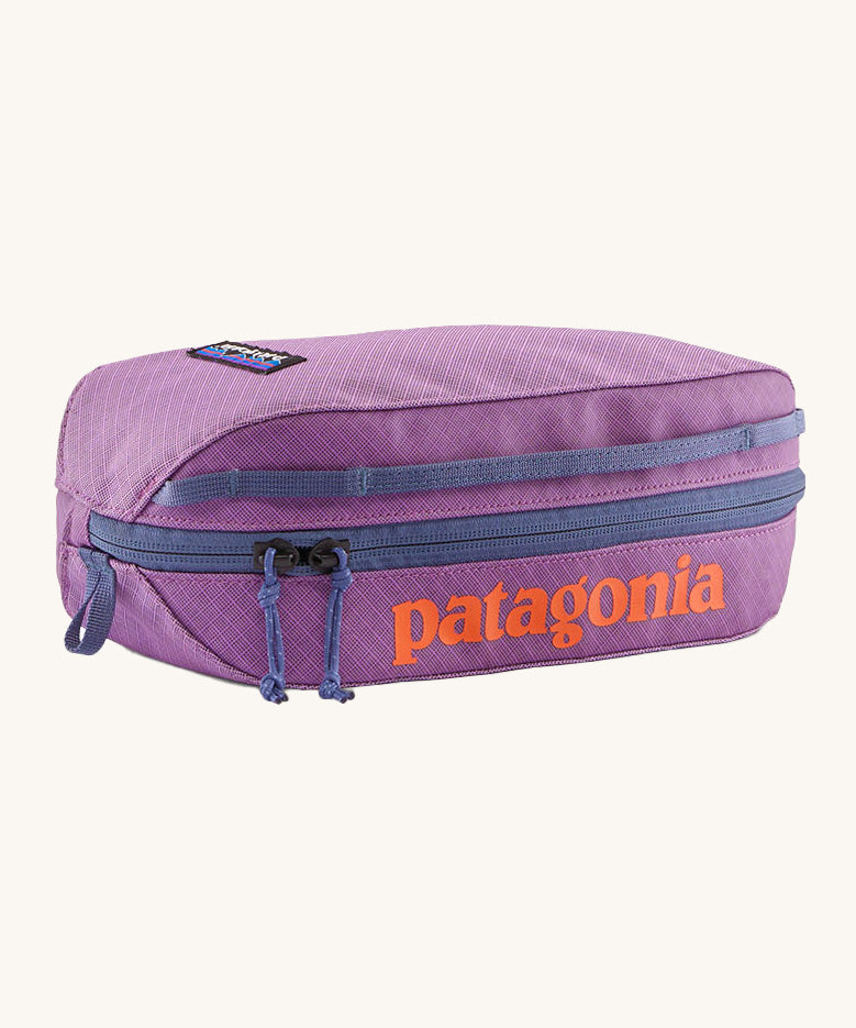 Patagonia 3L black hole cube bag in brisk purple. A 100% recycled bag in vibrant purple with a navy zip detail. Features a bran patch on side and  brand name print  in orange on the top side