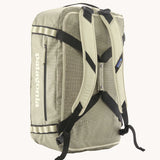 Back of Patagonia black hole duffel 55 litre bag in weathered stone with padded straps.