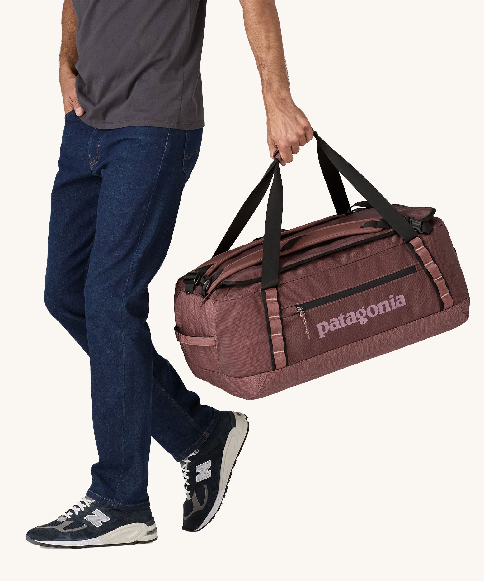A person holding a 55L Patagonia Black Hole Duffel bag.