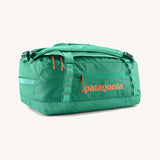 Patagonia black hole 40L duffel bag in aqua stone with orange printed logo and zip pulls. 