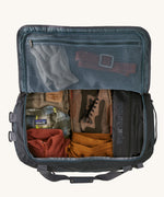 An open Patagonia Black Hole Duffel 55L bag. Contents can be seen inside including a pair of work boots and clothing. 