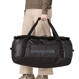 Person holding the Patagonia black Hole duffel bag 70L in black in their hand.
