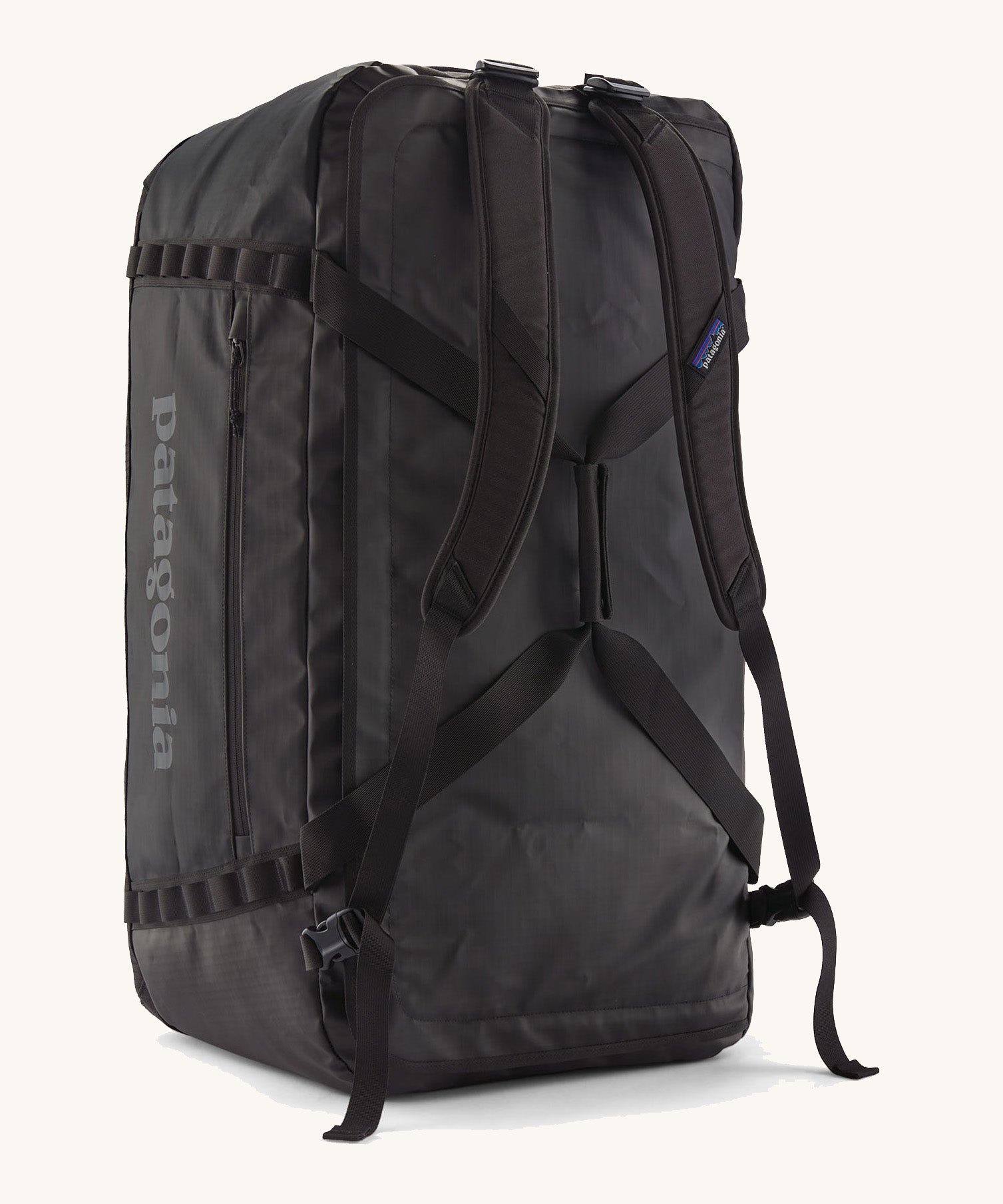 A back view of the large 100 litre capacity Patagonia Black Hole Duffel Luggage Bag, in monochrome all black., showing the shoulder straps. 