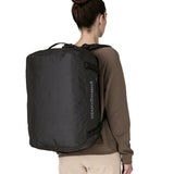 A woman wearing The Patagonia Black Hole 40 Litre Luggage Backpack in monochrome black on her back.