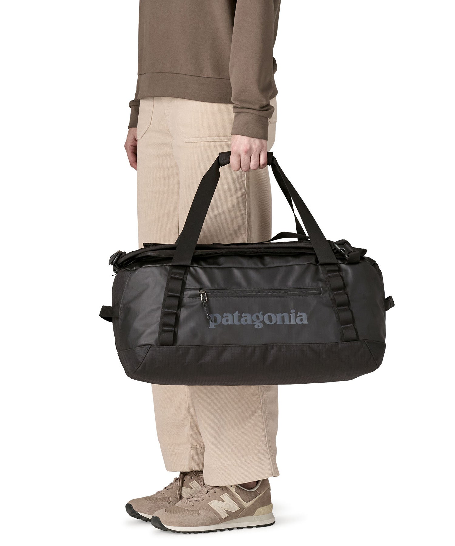A person holding The Patagonia Black Hole 40 Litre Luggage Backpack in monochrome black.