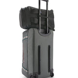 Patagonia Black Hole Pack 32L black attached securely to rolling luggage handle for easy travel.