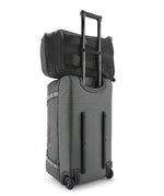 Patagonia Black Hole Pack 32L black attached securely to rolling luggage handle for easy travel.