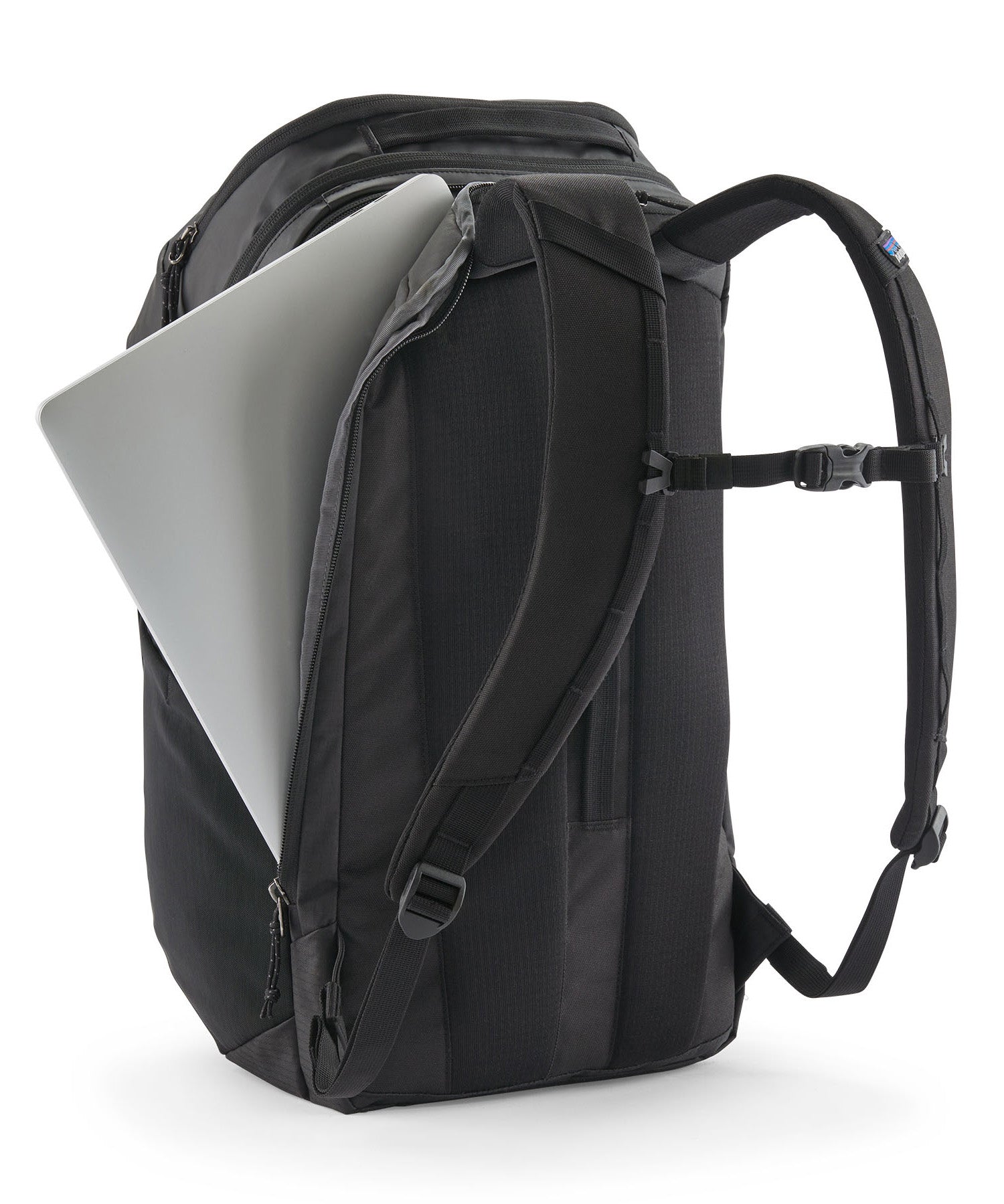 Patagonia Black Hole Pack 32L black travel backpack with laptop partially inserted in padded laptop compartment.