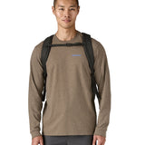 Front view of person wearing the Patagonia Black Hole Pack 32L black backpack with chest strap fastened.