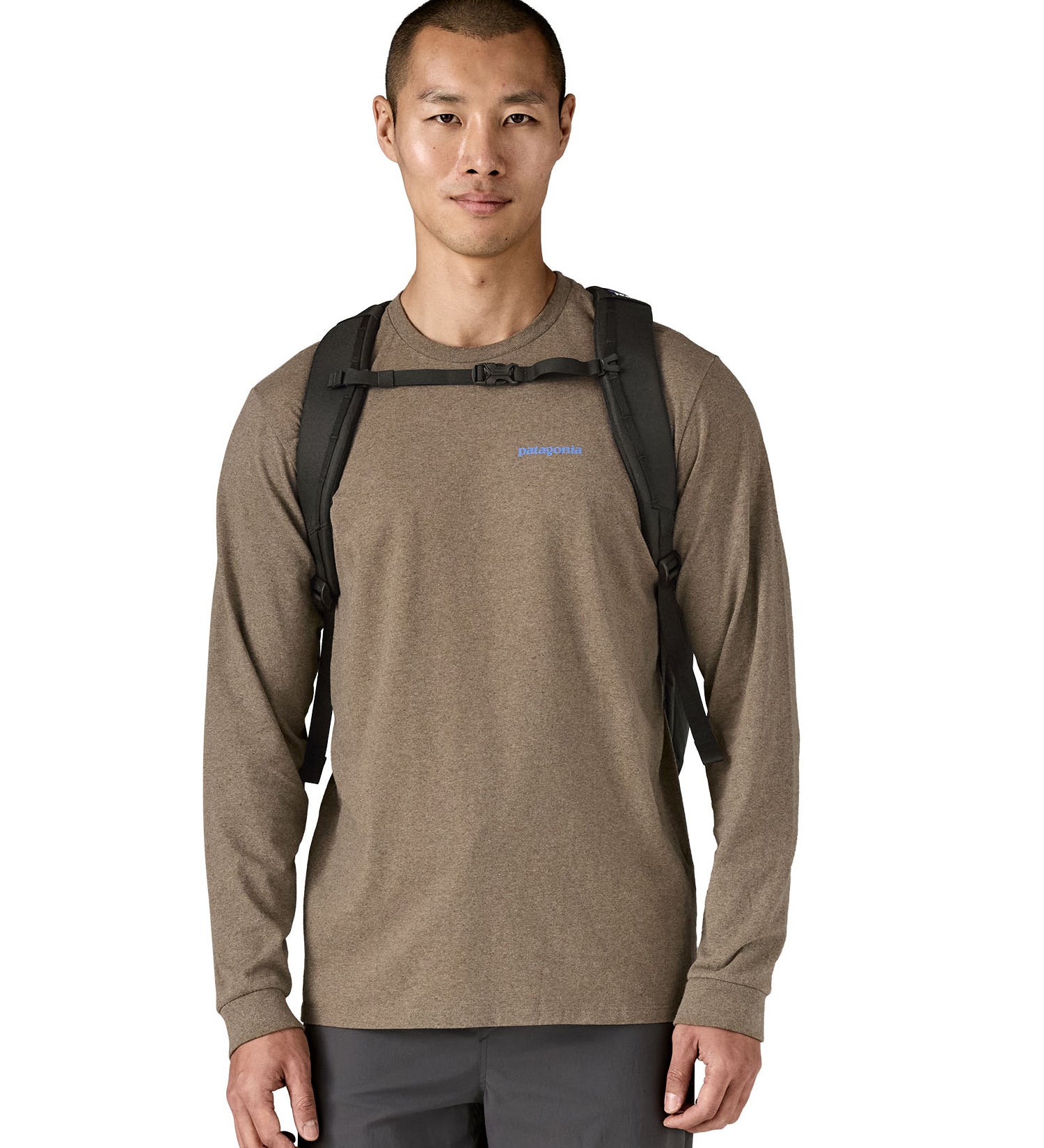 Front view of person wearing the Patagonia Black Hole Pack 32L black backpack with chest strap fastened.