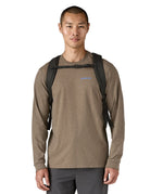 Front view of person wearing the Patagonia Black Hole Pack 32L black backpack with chest strap fastened.
