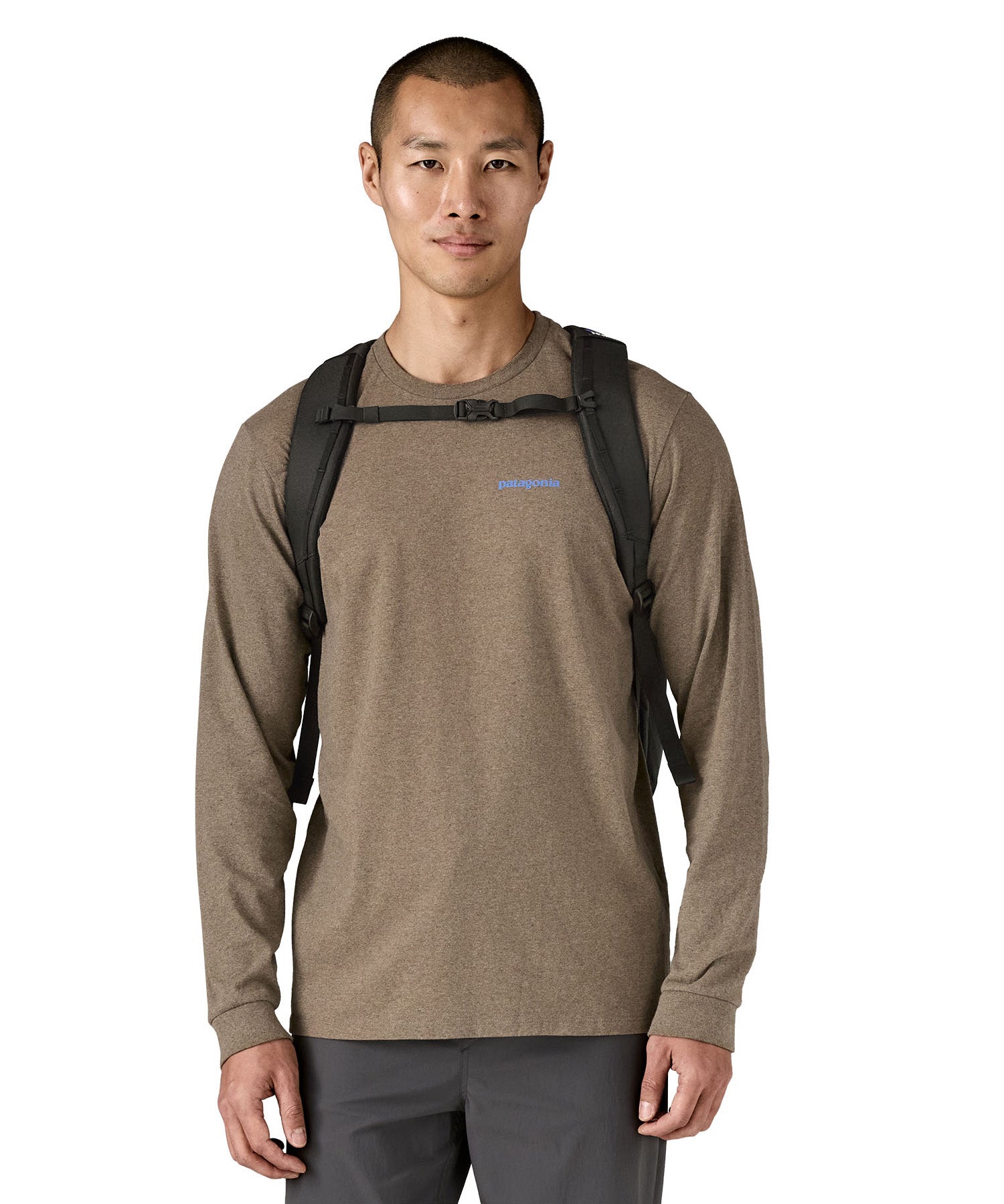 Front view of person wearing the Patagonia Black Hole Pack 32L black backpack with chest strap fastened.