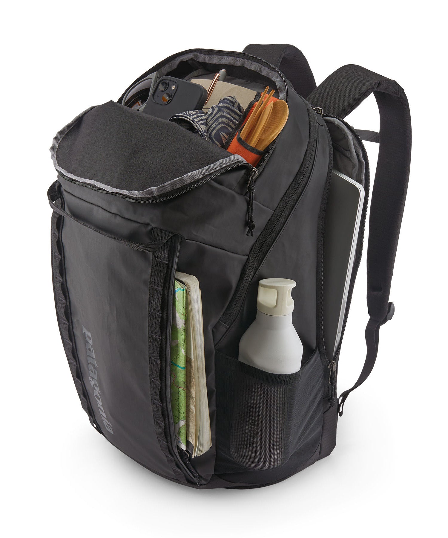 Patagonia Black Hole Pack 32L black shown open and filled with travel essentials, displaying internal organisation and side pockets.