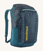 Patagonia 32L black hole backpack in a tidal teal colour on a cream background.