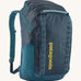 Patagonia 32L black hole backpack in a tidal teal colour on a cream background.