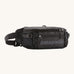 Patagonia black hole waist 5L pack in black on black. A 100% recycled nylon pack in black with black detail. Features 2 compartments with mesh side pockets and a buckle fastener 