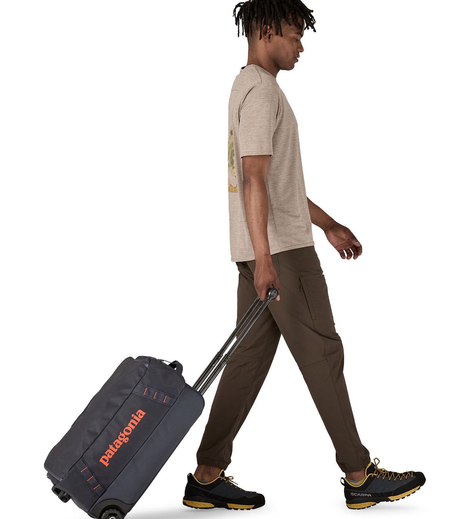 Patagonia 40L black hole wheeled duffel bag being pulled by an adult