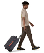 Patagonia 40L black hole wheeled duffel bag being pulled by an adult