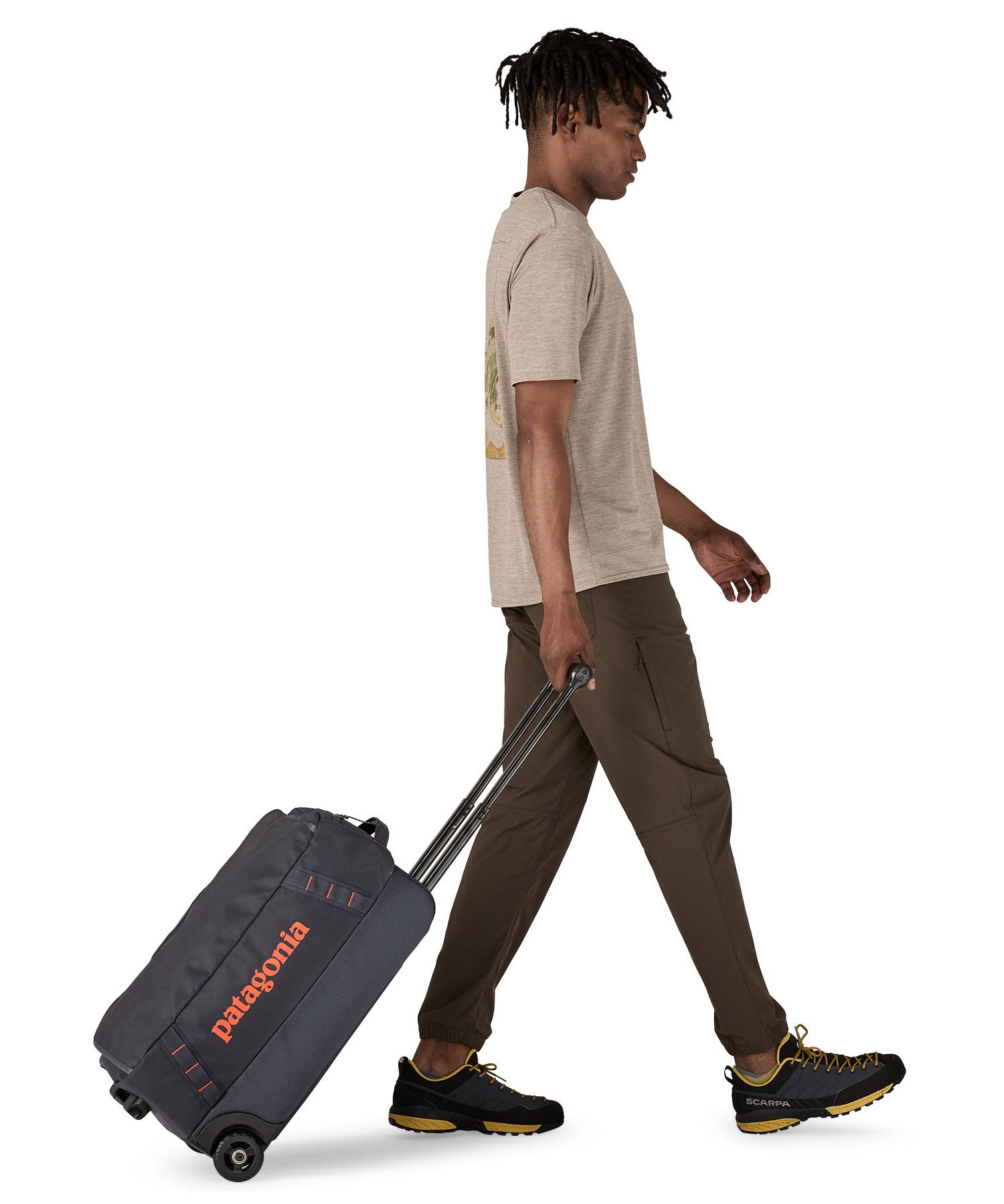 Patagonia 40L black hole wheeled duffel bag being pulled by an adult