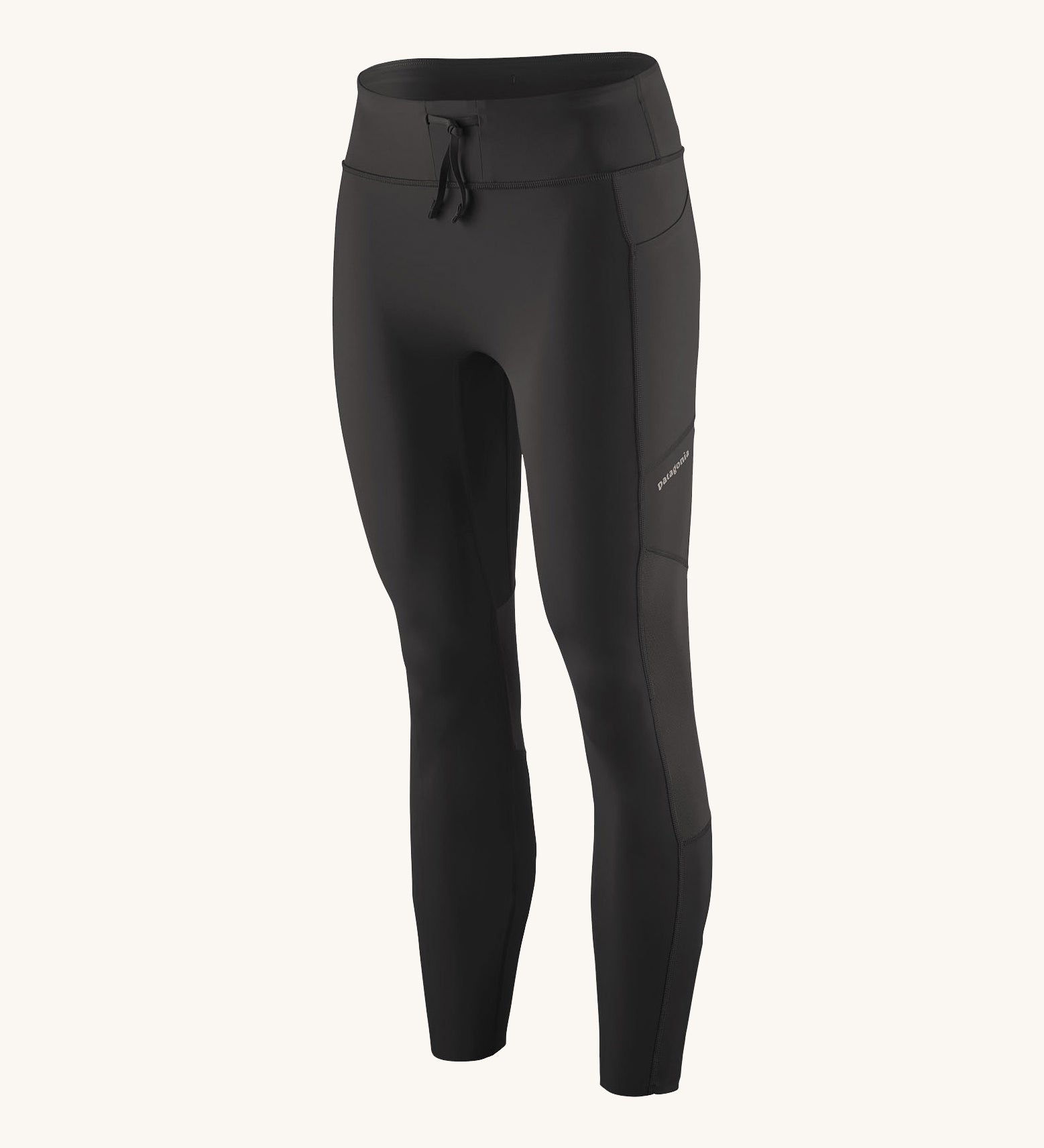 A pair of black Patagonia running 7/8 tights on a cream background.