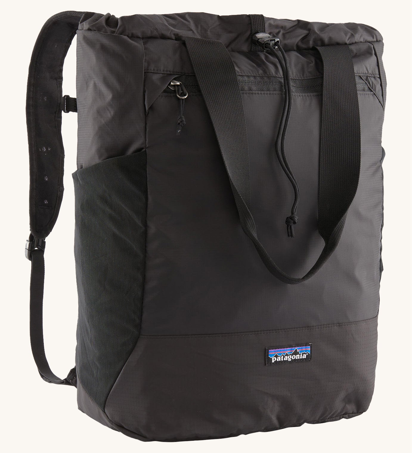 Patagonia Terravia tote bag in black showing the front zip and strap details with the brand log on the bottom panel. Features shoulder straps for easy carrying.