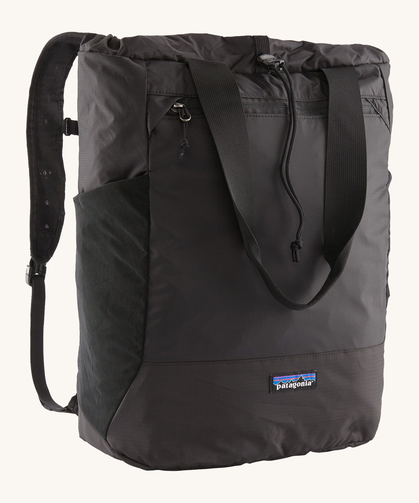 Patagonia Terravia tote bag in black showing the front zip and strap details with the brand log on the bottom panel. Features shoulder straps for easy carrying.
