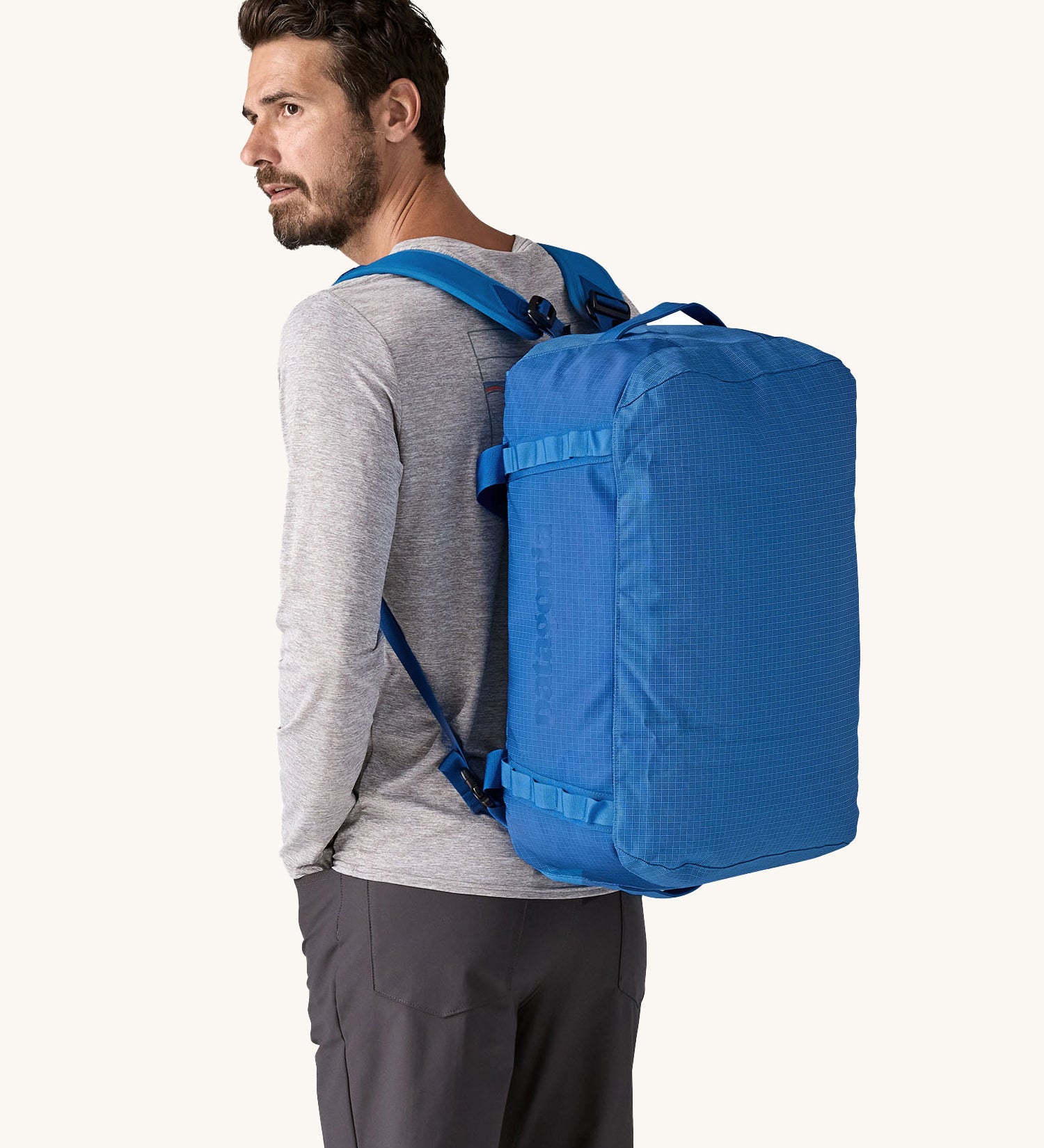A man wearing a 40L Patagonia duffel bag on his back. 