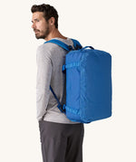A man wearing a 40L Patagonia duffel bag on his back. 