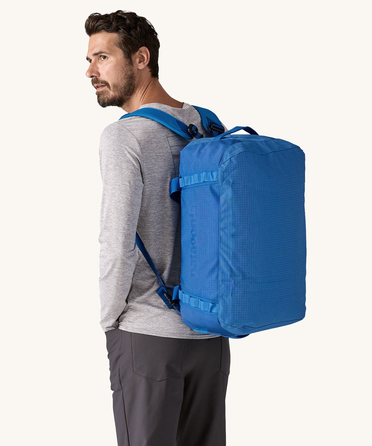 A man wearing a 40L Patagonia duffel bag on his back. 