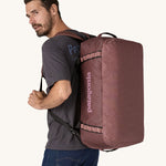 A person wearing a 55L Patagonia Black Hole Duffel bag on their back.