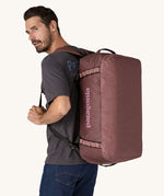A person wearing a 55L Patagonia Black Hole Duffel bag on their back.
