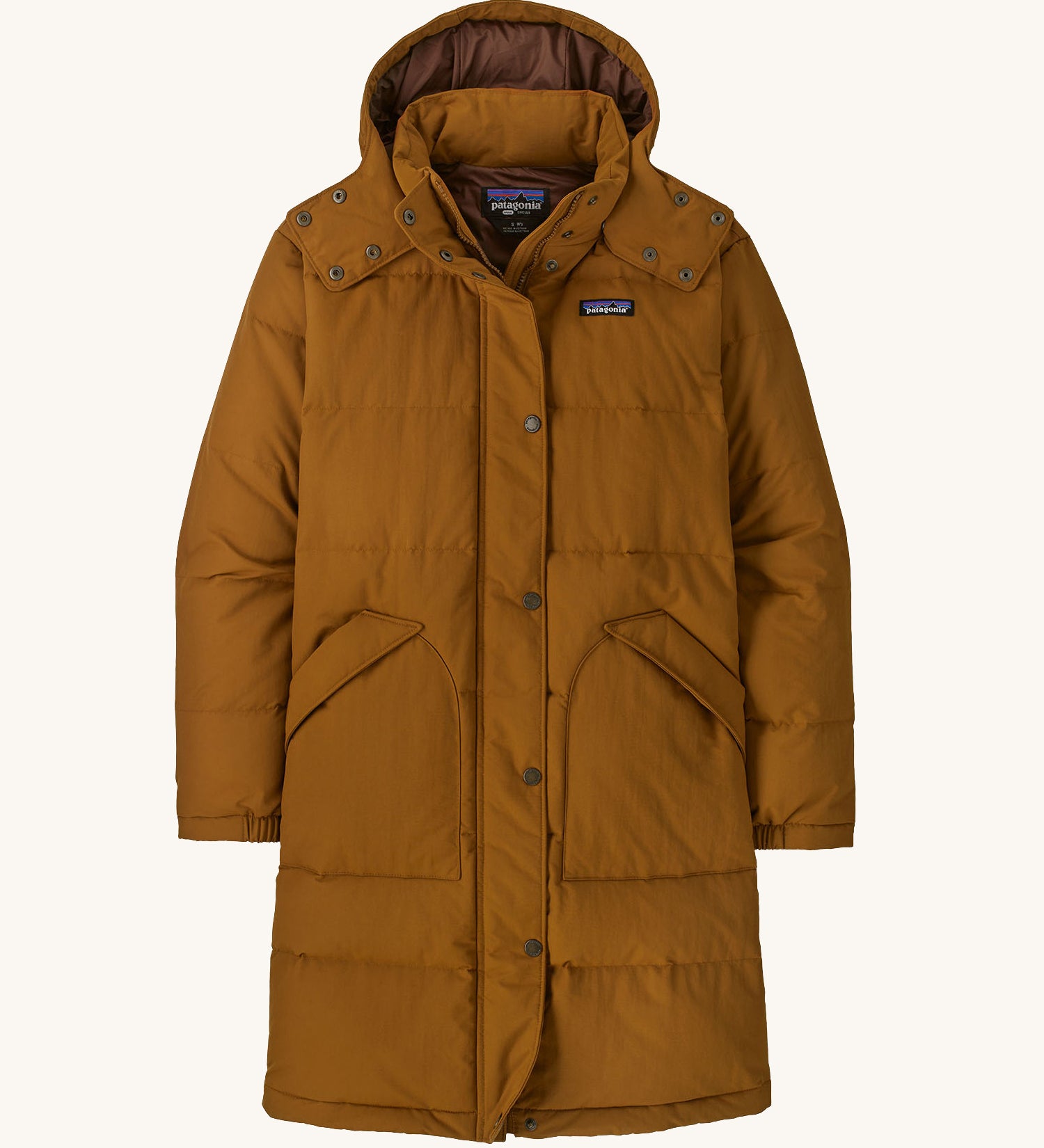 Patagonia parka in a brown colour on a cream background.