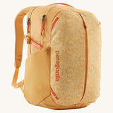 Patagonia yellow 26L day refugio backpack with a buttercup design on a cream background.