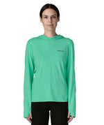 Woman wearing Patagonia's women's capilene cool sun hoody in light green with small brand logo on chest