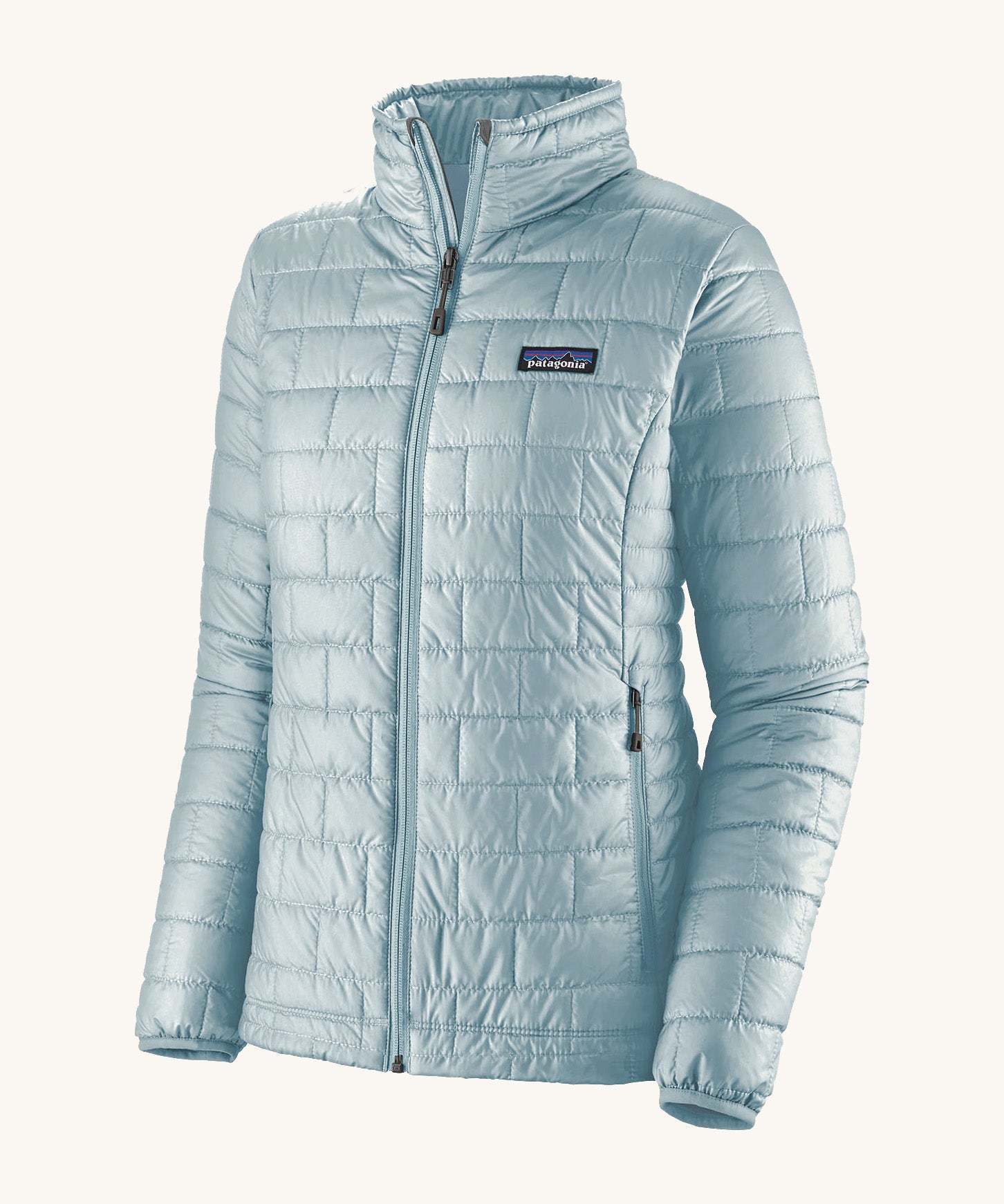 Patagonia women's nano puffer jacket in a chilled blue colour on a cream background.