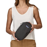 Patagonia cube Travel Bag 3L in a beeswax tan colour held by an adult