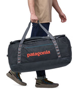 Patagonia 100 litres duffel bag in a navy blue colour carried by an adult side panel detail
