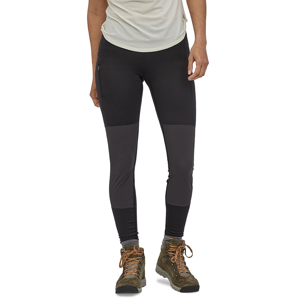 Close up of a woman stood on a white background wearing the Patagonia black pack out hike tights 